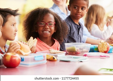 School kids eating packed lunches together at a table - Powered by Shutterstock