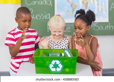 School Kids Looking Recycle Logo Box In Classroom At School