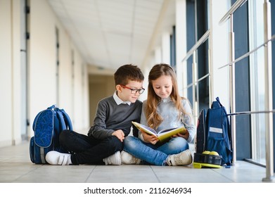 School kids reading book together in corridor. Conception of education. - Powered by Shutterstock