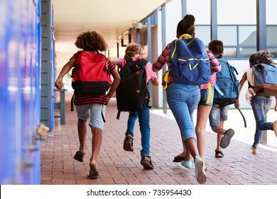 School Kids Running In Elementary School Hallway, Back View