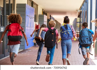 School Kids Running In Elementary School Hallway, Back View