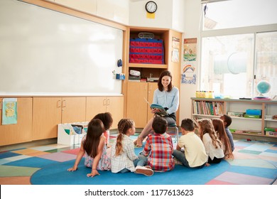 School Kids Sitting On The Floor Gathered Around Teacher