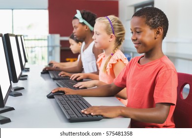 School Kids Using Computer In Classroom At School