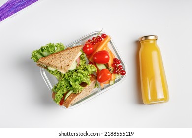 School lunch in box, container isolated on white background. Toasts, sandwiches, vegetable snack. Small kid's meal, take away school food. Kid's hands.