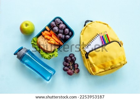 School lunch box with sandwich, fruits and water.