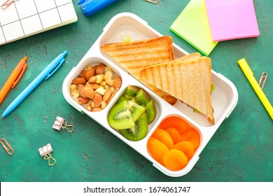 School Lunch Box With Tasty Food And Stationery On Table