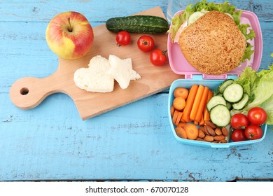 School lunch in boxes with apple on blue wooden table - Powered by Shutterstock