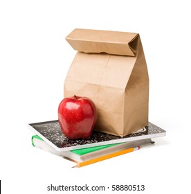 School lunch. Brown paper bag and a red apple on top of textbooks against white background. - Powered by Shutterstock