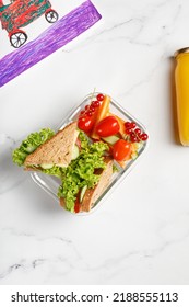 School lunch with a sandwich, toasts, vegetables, snack. Container with take away school food. Top view.
