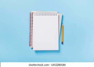 school notebook on a blue background, spiral notepad on a table. flatlay