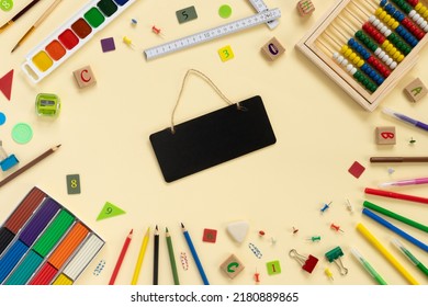 School And Office Supplies Border On Beige Paper Background. Multicolored Pencils, Paints, Plasticine, Abacus, Pushpins And Other School Accessories 
Flat Lay  Top View With Copy Space. Back To School