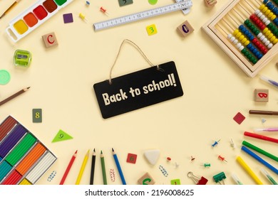 School And Office Supplies Border On Beige Paper Background. Multicolored Pencils, Paints, Plasticine, Abacus, Pushpins And Other School Accessories 
Flat Lay  Top View With Copy Space. Back To School