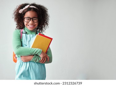 School, portrait of child student with books for knowledge, education and studying in a studio. Happy, smile and young smart girl kid with glasses for reading by a white background with mockup space.