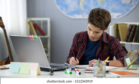 School Pupil Writing Notebook Doing Home Work At Table, Distance Education