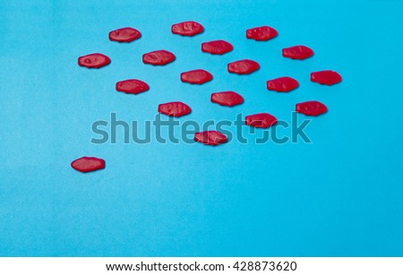 School of red candy fish with one detractor