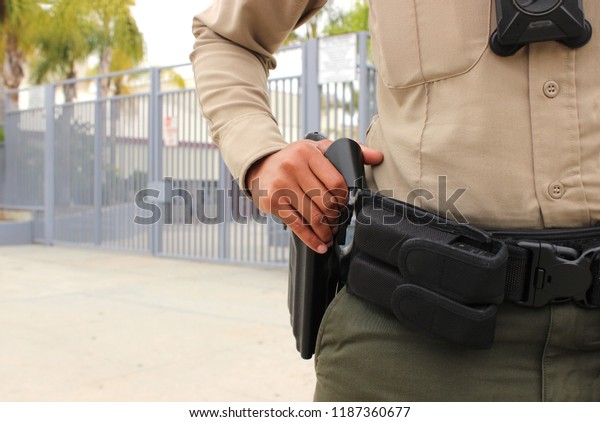 School safety concept -\
armed police officer on duty protecting a closed campus high school\
in California
