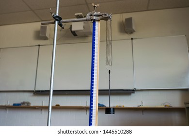 School Science Class Demonstrating Hooke's Law With Metal Spring And Weight