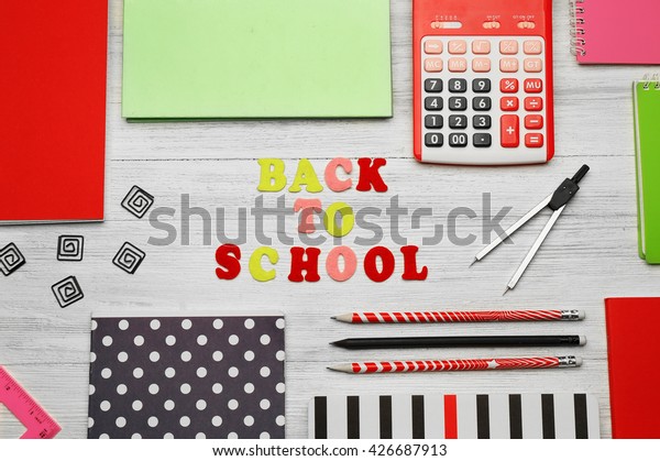 School set with back to school
inscription, notebooks and calculator on light wooden
background