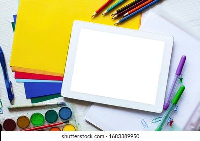 School set and office supplies set with digital tablet with blank white desktop screen, pencils, colored paper, paint, scissors, figures and glasses on white wooden background. Education concept - Powered by Shutterstock