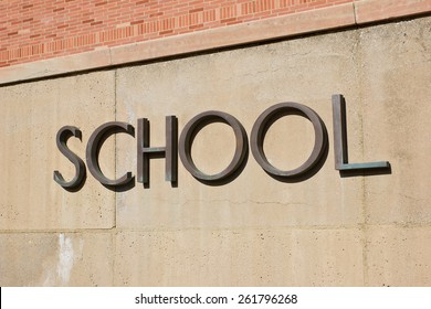 School sign on a concrete wall