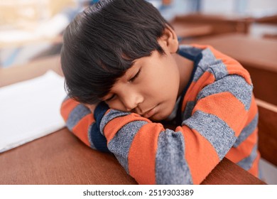 School, sleeping and tired with boy student in classroom for child development or learning. Burnout, exhausted and fatigue with learner kid asleep on desk in class for education, growth or study - Powered by Shutterstock