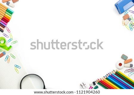 School stationery materials such as crayons, markers, clips, puncher, magnifying glass, erasers on white office table desk. Top view, flat lay with copy space
