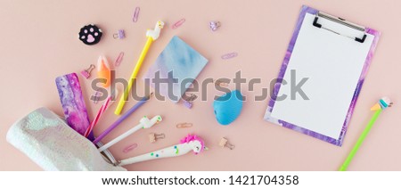 School stationery with unicorn pen, lama pencil on a pink background. Back to school creative table desk with kawaii stationery, flatlay and top view. Panoramic backdrop