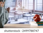 School stuff and schoolbag on a wooden desk in classroom interior. Copy space.