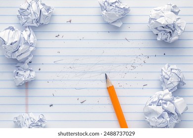 School supplies of blank lined notebook paper with eraser marks and erased pencil writing, surrounded by balled up paper and a sharp pencil. Studying or writing mistakes concept.