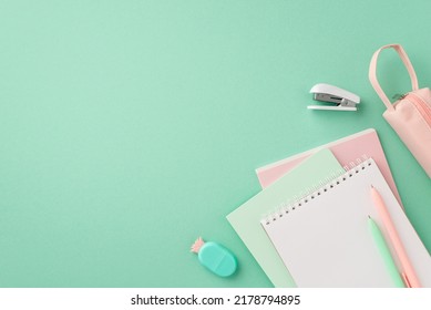 School supplies concept. Top view photo of stylish stationery notebooks pineapple shaped eraser pens pink pencil-case and mini stapler on isolated pastel green background with copyspace - Powered by Shutterstock