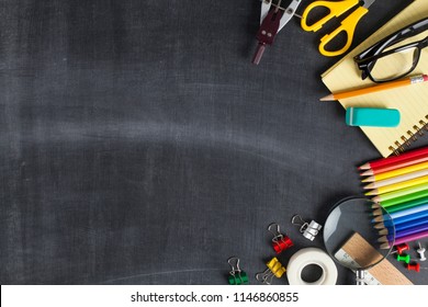 School supplies on black board background. Back to school concept