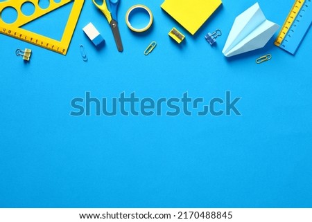 School supplies on blue background. Top view with copy space. Back to school concept.