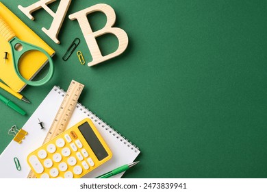 School supplies organized on a green background, including a calculator, ruler, and notebook - Powered by Shutterstock