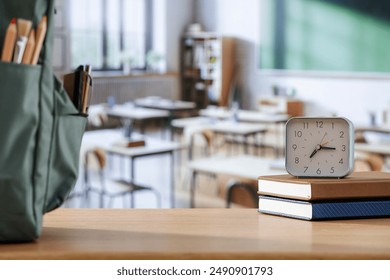 School supplies and schoolbag on wooden school desk. Blurred classroom background and copy space for school stuff and stationery on wooden desk.  - Powered by Shutterstock