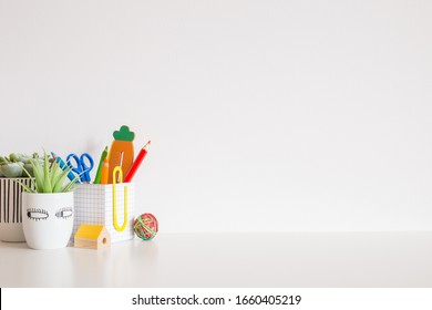 School supplies and succulent plant near bright white wall with copy space. - Powered by Shutterstock