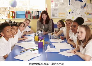 School Teacher And Class Working On Project Look To Camera