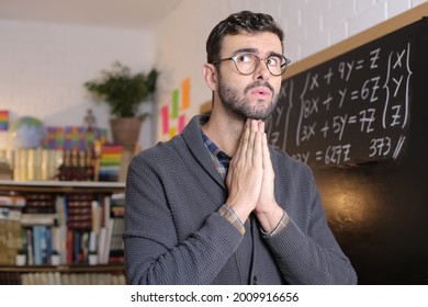 School Teacher Praying In Classroom