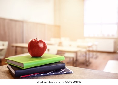 School Teacher's Desk With Stack Of Books And Apple