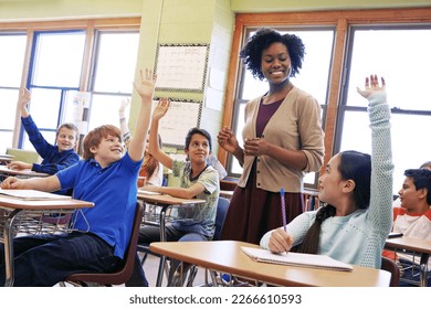 School, tutor and students raise their hands to ask or answer an academic question for learning. Diversity, education and primary school kids speaking to their woman teacher in the classroom. - Shutterstock ID 2266610593