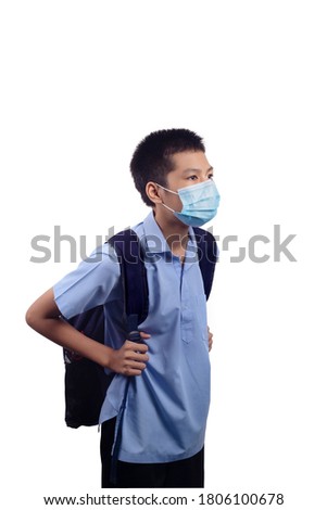 ฺBoy in school uniform, carrying a backpack, school supplies, wearing a disposable medical mask, standing two meters apart, the concept is Socialdistancing. To prevent COVID-19 infection