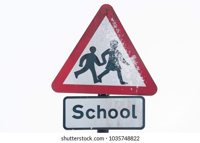 A School Warning Road Sign, In Snow UK, A Concept Of Road Hazard With Snowy Roads.