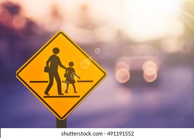 School Zone Warning Sign On Blur Traffic Road With Colorful Bokeh Light Abstract Background. Copy Space Of Transportation And Travel Concept. Vintage Tone Filter Color Style.