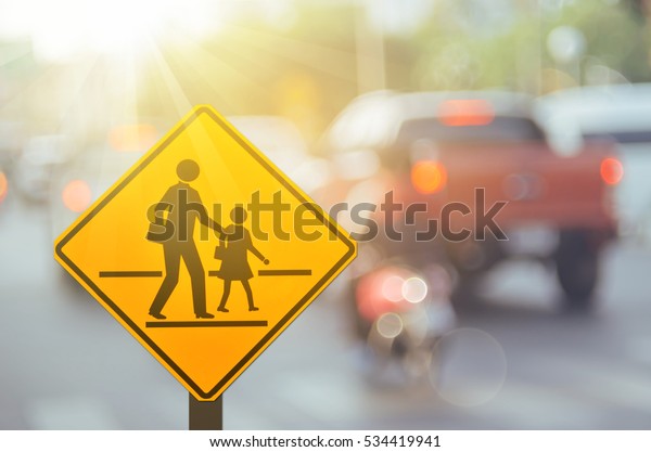 School zone\
warning sign on blur traffic road with colorful bokeh light\
abstract background. Copy space of transportation and travel\
concept. Vintage tone filter color style.\
