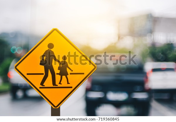 School\
zone warning sign on blur traffic road with colorful bokeh light\
abstract background. Copy space of transportation and travel\
concept. Vintage tone filter effect color\
style.