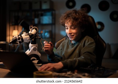 A school-age boy develops a passion for electronics. The child assembles a robot, looks for instructions, help on the internet, scrolls on a laptop, pulls cables from a toy