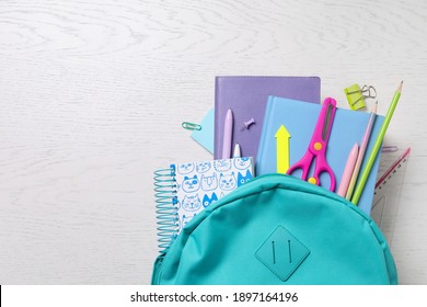 Schoolbag With Books And Stationery On Wooden Table, Flat Lay. Space For Text