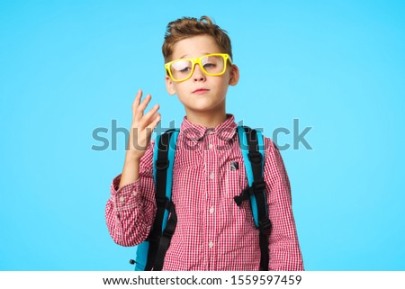 Schoolboy with backpack glasses learning fun studio shirt