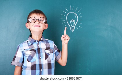 Schoolboy at blackboard in classroom - Shutterstock ID 218865874