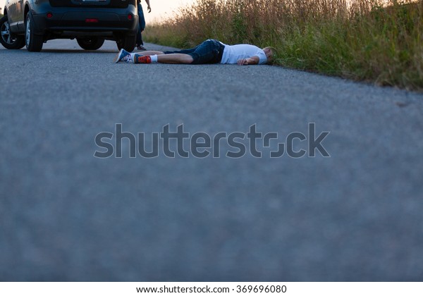 Schoolboy Bumped by a Private Vehicle, Lying Dead\
Behind the Car on an Empty\
Road