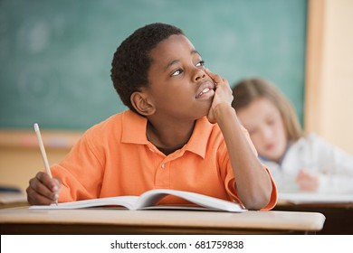 Schoolboy daydreaming in classroom - Powered by Shutterstock